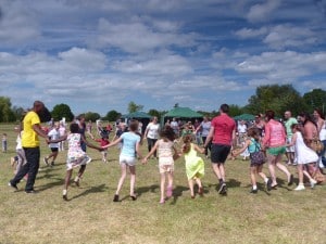 A parents' and children's dance session on Poulshott village green, Wiltshire